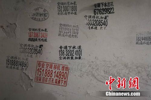 圖為北京一小區(qū)樓道內(nèi)的空調(diào)維修小廣告。 謝藝觀 攝