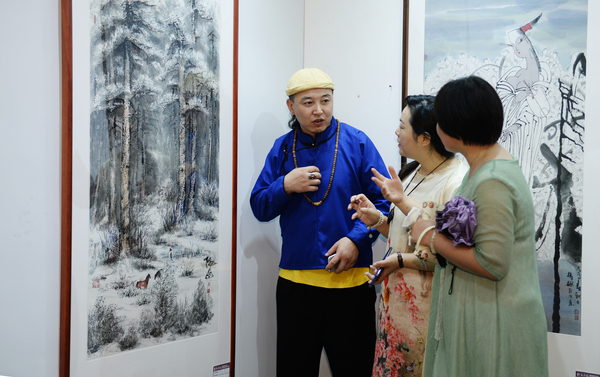 7、聚集在北京宋莊的內(nèi)蒙古畫(huà)家阿拉騰在向觀眾介紹他的作品