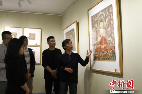 圖為主創(chuàng)者高志勇向參觀嘉賓介紹拍攝作品?！≮w朗 攝