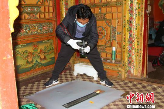 圖為西藏自治區(qū)古籍保護(hù)中心古籍保護(hù)部副主任才洛采集古籍影像信息?！≮w朗 攝