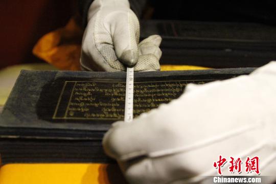 圖為羅布林卡管理處工作人員測(cè)量古籍尺寸?！≮w朗 攝