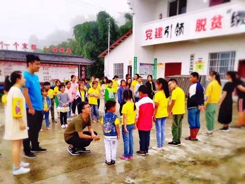 西南交通大學(xué)“砥力筑夢(mèng)”暑期社會(huì)實(shí)踐隊(duì)隊(duì)員與貧困地區(qū)小朋友們玩“蘿卜蹲”游戲。