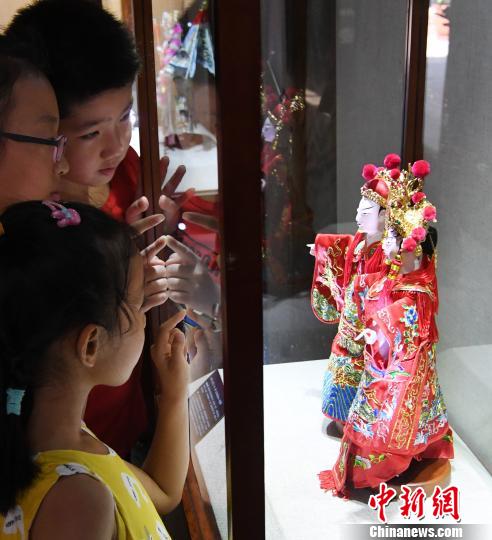 參展木偶頭木雕作品《狀元·夫人》吸引觀展孩子們目光?！∮浾邉⒖筛?攝