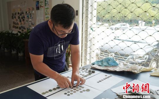 工作人員在研究古錢幣“身份”?！盍⒊?攝