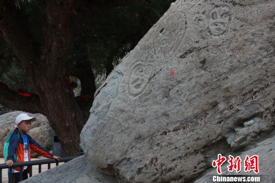 在寧夏賀蘭山巖畫(huà)景區(qū)內(nèi)，這在觀看巖畫(huà)的游客?！∮诰?攝
