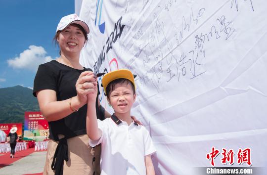 圖為坦洋村民在助威冬奧的條幅上簽字。　夏波光 攝