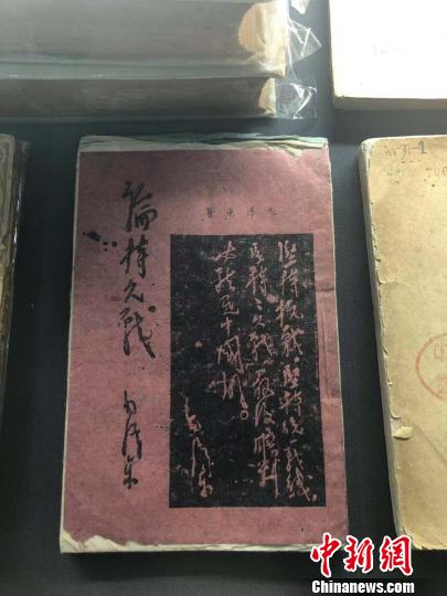 一本用白、紅、藍(lán)等五種顏色紙張印刷而成的《論持久戰(zhàn)》。　李庭耀 攝