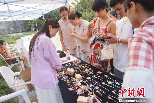 游客在首飾攤位前駐足?！堨蠚g 攝