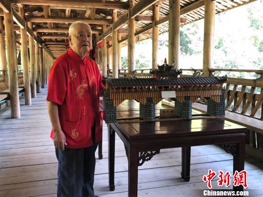 圖為黃春財(cái)展示“雙龍橋”模型?！∨砝蚍?攝
