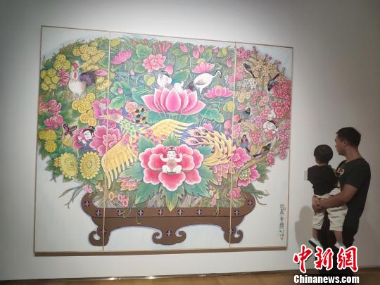一位父親帶著孩子觀看展覽?！√菩∏?攝