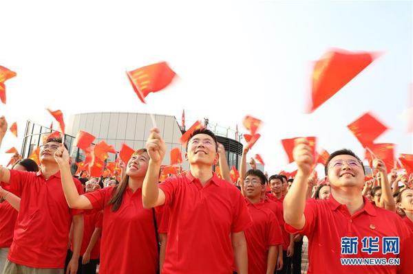 9月26日，在廣東東莞民盈·國貿(mào)中心，粵港澳青年揮舞國旗，合唱《歌唱祖國》。新華社記者 李嘉樂 攝