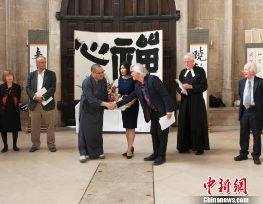 英國皇家水彩協(xié)會前主席大衛(wèi)·帕斯特(右3)與月真法師(左3)握手，恭賀展覽開幕 。??　王子嵐 攝