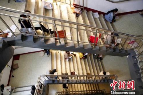 圖為考研生坐在樓梯上專心背誦?！O宏瑗 攝