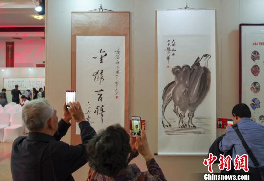 9日，觀眾在“慶祝中華人民共和國成立70周年——影視藝術(shù)家優(yōu)秀書畫作品展”上參觀六小齡童的書法作品《金猴吉祥》和趙忠祥的畫作《大漠之舟》?！?lt;a target='_blank' href='http://www.chinanews.com/'>中新社</a>記者 賈天勇 攝