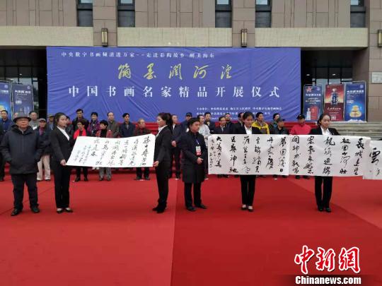 圖為書畫家在中國書畫名家精品開展儀式現(xiàn)場進行書法創(chuàng)作，并展示作品?！◆?shù)り?攝