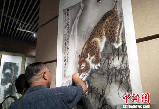 觀眾欣賞六尺國(guó)畫掛軸《豹子覓泉圖》。主辦方供圖