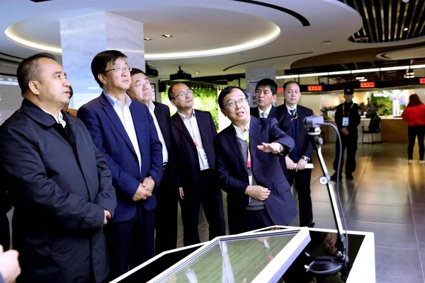 圖為民盟中央農(nóng)業(yè)委員會委員、楊凌示范區(qū)科技創(chuàng)新和轉(zhuǎn)化推廣局副局長、楊凌示范區(qū)科創(chuàng)中心（楊凌大學(xué)科技園）建設(shè)領(lǐng)導(dǎo)小組辦公室常務(wù)副主任王博文（右一）向前來參觀的新疆維吾爾自治區(qū)黨委常委、副主席艾爾肯?吐尼亞孜一行介紹情況。