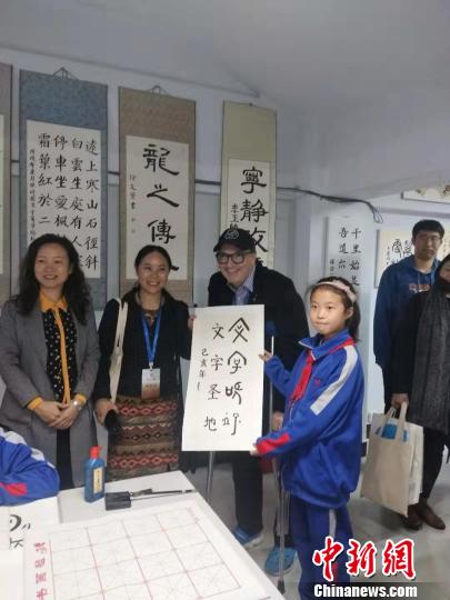 圖為外國漢學(xué)家與孩子交流書法?！畲笥?攝