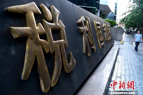 圖為廈門市民從稅收宣傳標(biāo)語旁經(jīng)過。(資料圖片)<a target='_blank' href='http://www.chinanews.com/'>中新社</a>記者 張斌 攝