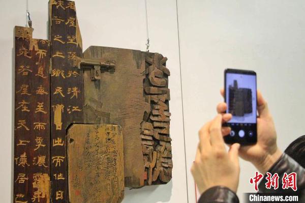 圖為觀眾在刻字作品前駐足拍照?！≮w曉 攝