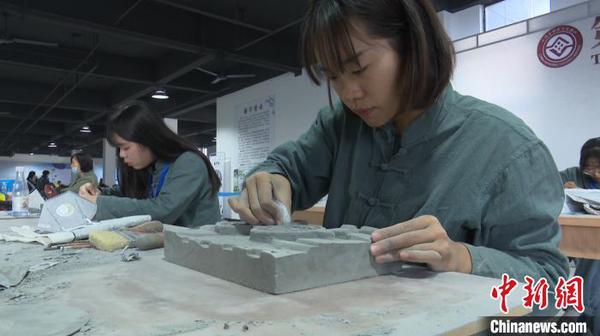 11月11日，在安徽黃山舉辦的全國磚雕傳統(tǒng)技藝大賽上，年輕的女磚雕藝人正在忙碌著?！Ⅷ欪Q 攝