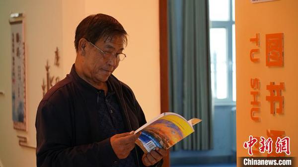 圖為社區(qū)居民在圖書漂流站看書?！∥航ㄜ?攝