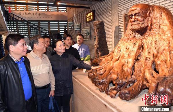 來(lái)賓觀看展出的中國(guó)工藝美術(shù)大師林學(xué)善代表作品《達(dá)摩》?！∮浾邉⒖筛?攝