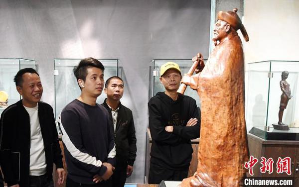 觀眾觀看由中國(guó)工藝美術(shù)大師林學(xué)善創(chuàng)作的木雕作品《林則徐》。　記者劉可耕 攝