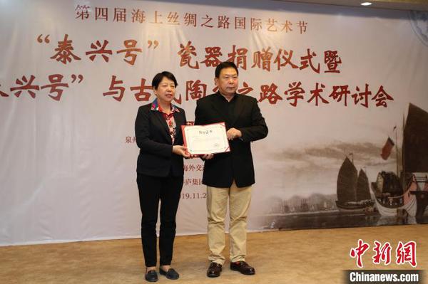 泉州市副市長(zhǎng)周真平(左)為“泰興號(hào)”沉船瓷器捐贈(zèng)者鄭長(zhǎng)來(lái)頒發(fā)收藏證書(shū)?！＄娦?攝