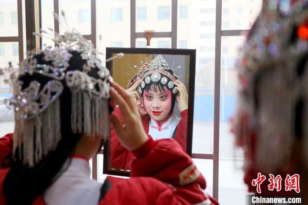 圖為甘肅省文理學(xué)院戲曲表演專業(yè)學(xué)生登臺演出前化妝?！「呖档?攝