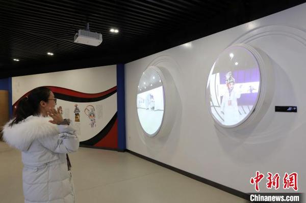 市民在寧夏銀川市秦腔傳承保護(hù)基地體驗(yàn)室內(nèi)利用投影“換”上秦腔人物行頭?！±钆迳?攝