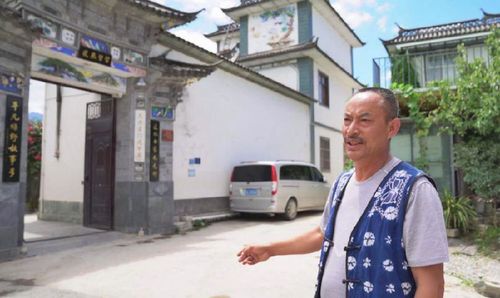 李德昌在自家門口介紹保護傳統村落文化的措施（2019年8月10日攝）。