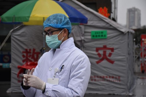 戴上一次性手套、一次性口罩、一次性帽子，穿著白大褂的譚曉鵬開始了一天的工作
