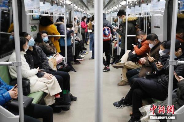 2月28日，乘客戴著口罩乘坐上海地鐵出行。近日，隨著上海企業(yè)全面復(fù)工，上海地鐵客運(yùn)量回升，高峰時(shí)段車廂滿載率平均在五成左右。 中新社記者 殷立勤 攝