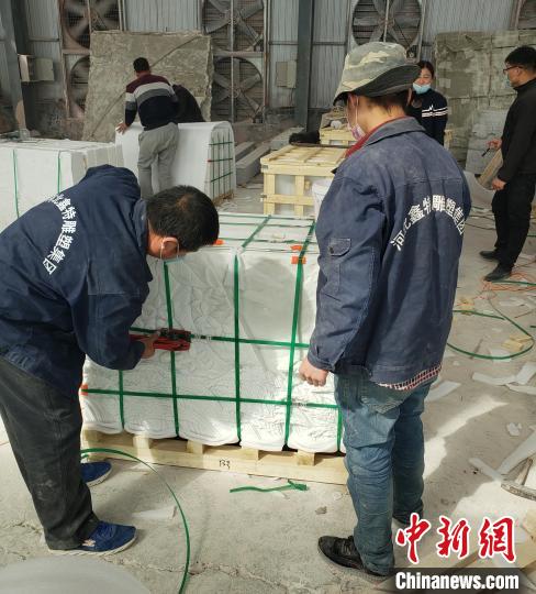 工人們在對驗(yàn)收后的《埃塞贊歌》浮雕墻分包裝箱。　薄麗麗 攝
