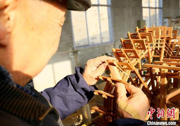 圖為段怡村正在進(jìn)行黃河水車制作?！「呖档?攝