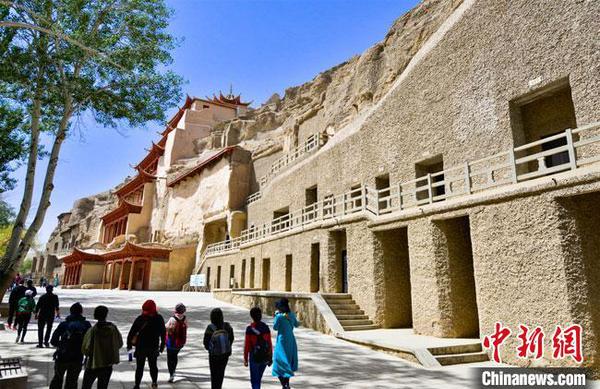 游客預(yù)約成功后，在采取了體溫測量、佩戴口罩等防控措施后，有序進(jìn)入敦煌莫高窟景區(qū)參觀游覽?！⊥醣筱y 攝