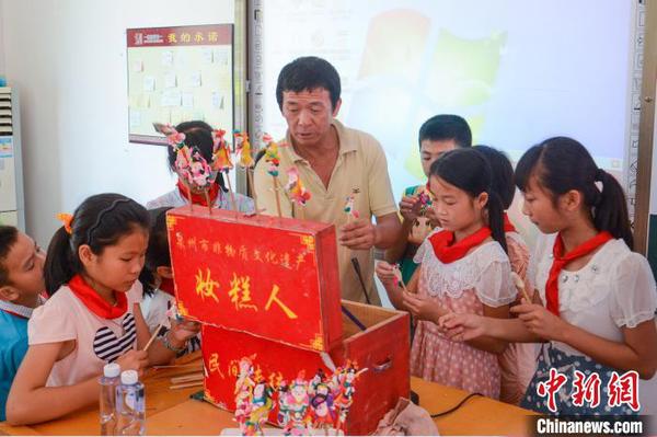 張明鐵到學(xué)校為孩子們教授“妝糕人”制作技藝?！埶囆?攝