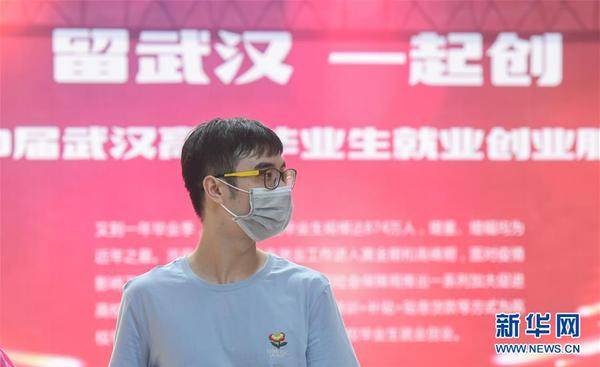一名求職者在江漢大學(xué)校園內(nèi)舉辦的招聘會現(xiàn)場尋找合適的崗位（6月1日攝）。這是疫情發(fā)生后，武漢舉辦的首場高校畢業(yè)生專場線下招聘會。 新華社記者 程敏 攝