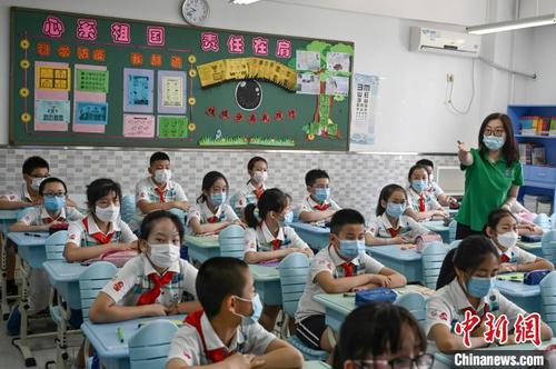 資料圖：小學生佩戴口罩返校復課?！埮d龍 攝