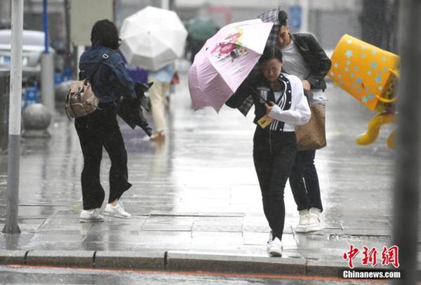 資料圖：市民頂風(fēng)冒雨出行。 中新社記者 張瑤 攝