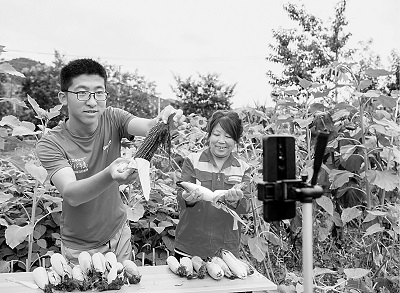 山西平順縣南坡村大學(xué)生王亞鵬（左）回村創(chuàng)業(yè)成為“新農(nóng)人”，圖為他正在直播銷售農(nóng)產(chǎn)品。新華社發(fā)
