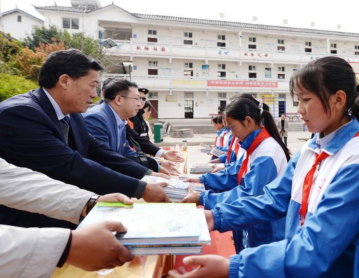 北京公益服務(wù)發(fā)展促進(jìn)會(huì)常務(wù)副會(huì)長(zhǎng)兼秘書長(zhǎng)、北京市昌平區(qū)政協(xié)委員孫鵬飛（左二）及出席捐贈(zèng)儀式的嘉賓向小學(xué)生捐贈(zèng)圖書