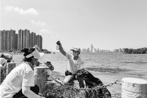 2020年8月5日，湖南衛(wèi)視志愿服務(wù)隊的志愿者們參與河流守望者組織的凈灘行動，清理河灘垃圾。河流守望者供圖