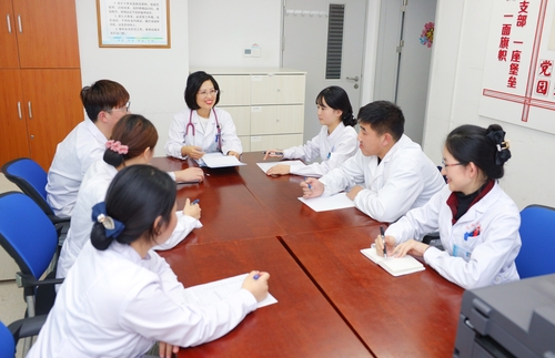 毛莉（居中）與同事們一起討論工作。（圖片由受訪者提供）