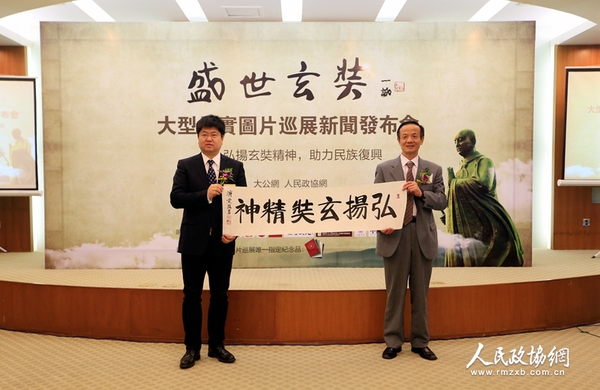 中國(guó)佛教協(xié)會(huì)常務(wù)理事陳星橋與大公報(bào)社長(zhǎng)助理、北京分社社長(zhǎng)、大公網(wǎng)執(zhí)行總裁兼總編輯王文韜展示中國(guó)佛教協(xié)會(huì)駐會(huì)副會(huì)長(zhǎng)演覺(jué)法師的墨寶——《弘揚(yáng)玄奘精神》（攝影：姚勇）