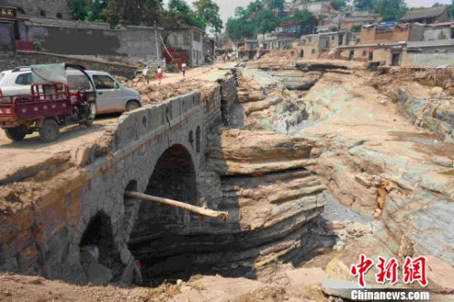 此次山洪將臺(tái)頭村公路連同下面的垃圾完全沖走，暴露出古河道當(dāng)年的面貌?！埛?攝